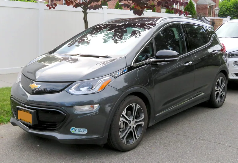 A dark gray 2017 Chevrolet Bolt EV Premier, seen from the front left, parked on a residential street.