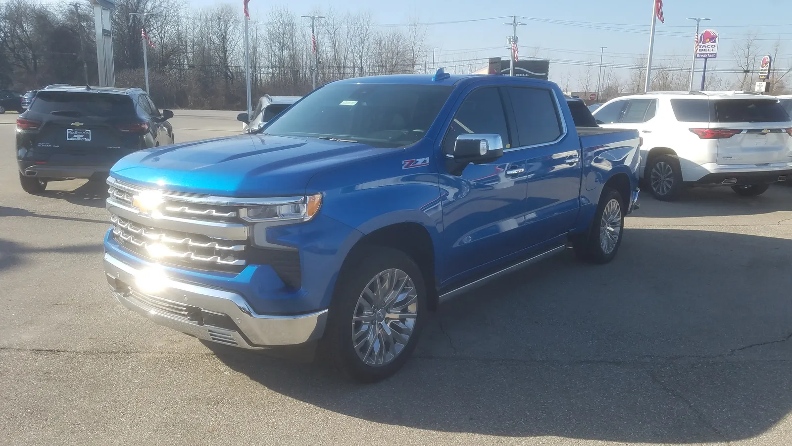 A blue 2022 Chevrolet Silverado LTZ crew cab with a Z71 badge, parked on a dealer lot, seen from the front left.