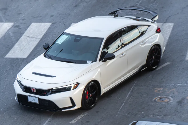 A white Honda Civic Type R with its rear wing, seen from above and the front left (driver side) on a Washington, D.C.-area street; photographed in January 2025, so an earlier model year than the 2027.