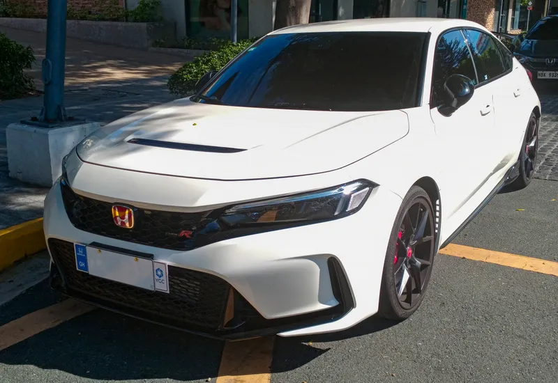 A white 2024 Honda Civic Type R seen from the front left (driver side), parked in Metro Manila, Philippines. It predates the 2027 car, so its front fascia is not the redesigned one.