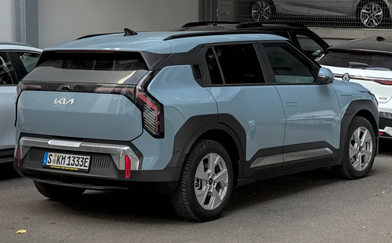 A light blue-gray Kia EV3 seen from the rear right three-quarter angle, parked in Stuttgart, Germany, in November 2024. It is a European-market car with a German plate, not a US-market 2027 EV3.