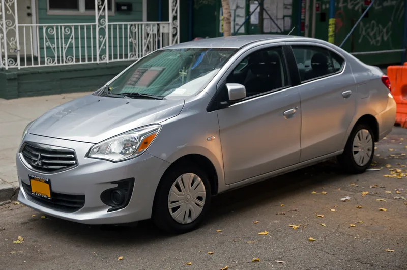 A silver 2017 Mitsubishi Mirage G4 sedan, seen from the front left, parked on a city street.