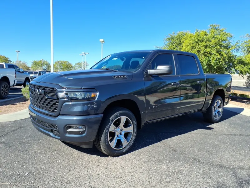 A dark gray 2026 Ram 1500 Express crew cab pickup parked in a lot, seen from the front left three-quarter angle, its driver's side facing the camera.